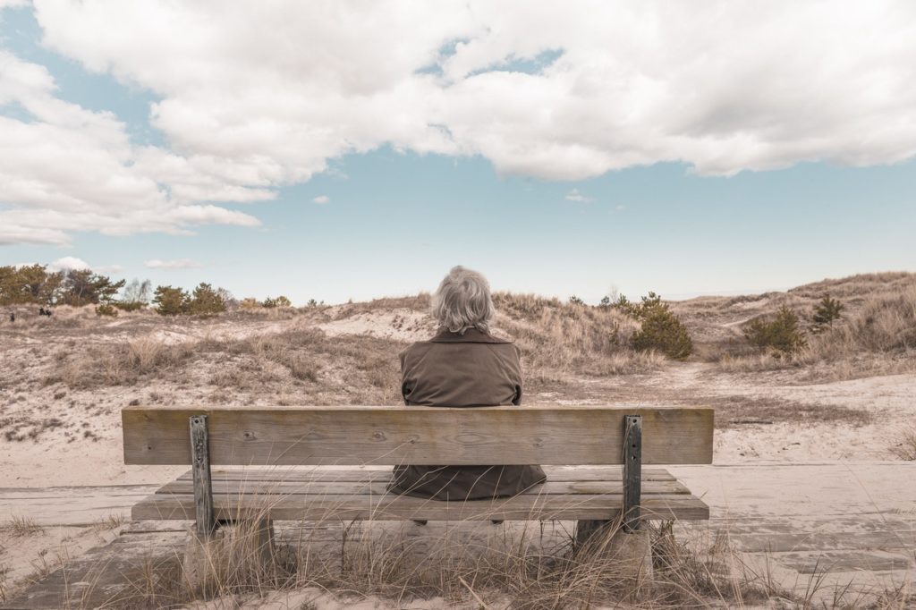 A person sits alone on the bench observing the scenery.