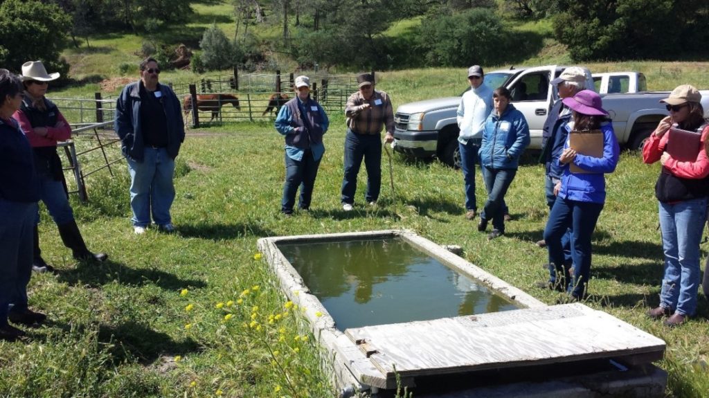 Joe Spencer explaining wildlife-friendly livestock trough design at ranch tour. Photo courtesy of Karminder Brown.