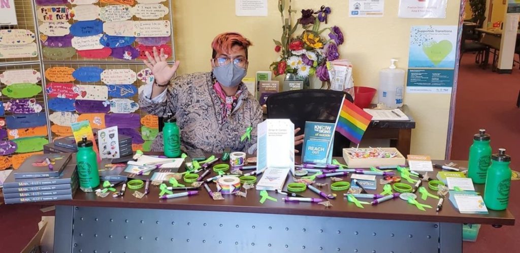San Benito+ peer mentor Balam Ruiz welcoming visitors to the Esperanza Center with resources and give aways. Photo courtesy of Juan Gutierrez.